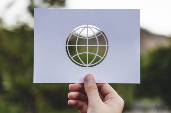 Hand Hold Globe Paper Carving with Nature Background Hand Hold Globe Paper Carving with Nature Background